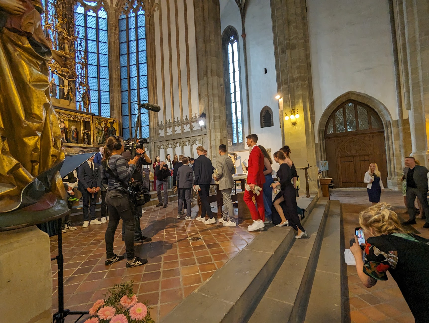 Jugendliche steigen zum Altarraum einer Kirche empor