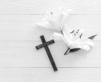 ein Kreuz und eine Blume liegen nebeneinander