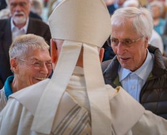 Zwei Menschen reden mit einem Bischof