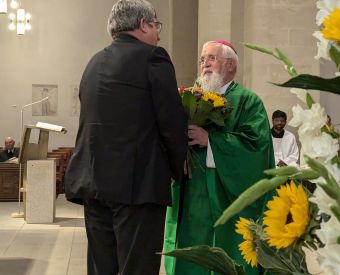 Zwei Männer gratulieren einander mit Blumen