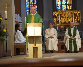 Ein Priester steht am Ambor