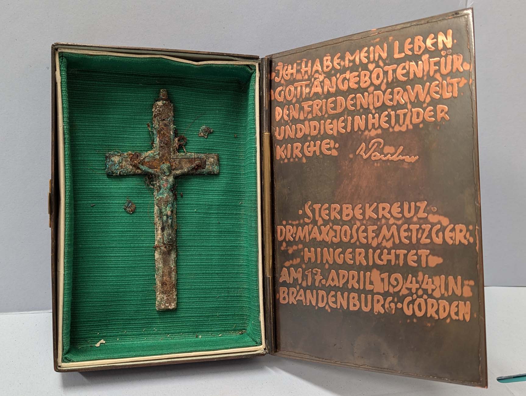 EIn Metallkreuz in einem Kasten