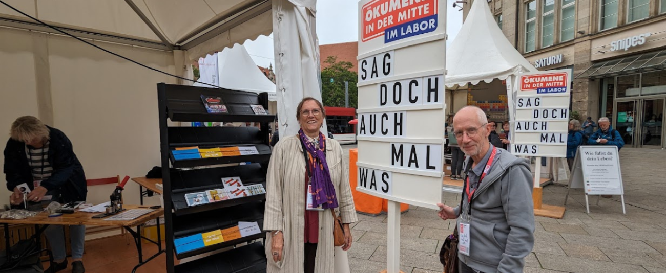 Zwei Menschen stehen neben einem Schild 