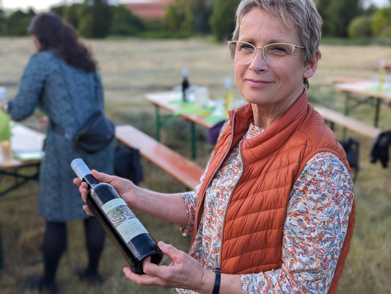 Eine Frau hält eine Flasche Wein