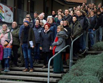 Menschen stehen auf einer Treppe und singen