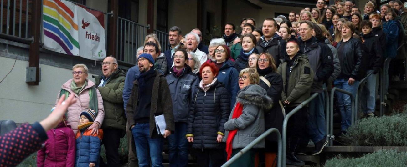 Menschen stehen auf einer Treppe und singen